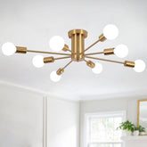 Gold ceiling light fixture with multiple white bulbs in a room with a window and plant.